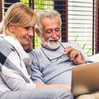 elder couple looking at laptop talking about estate planning