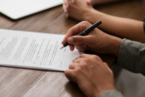 hand signing a personal representative form for estate