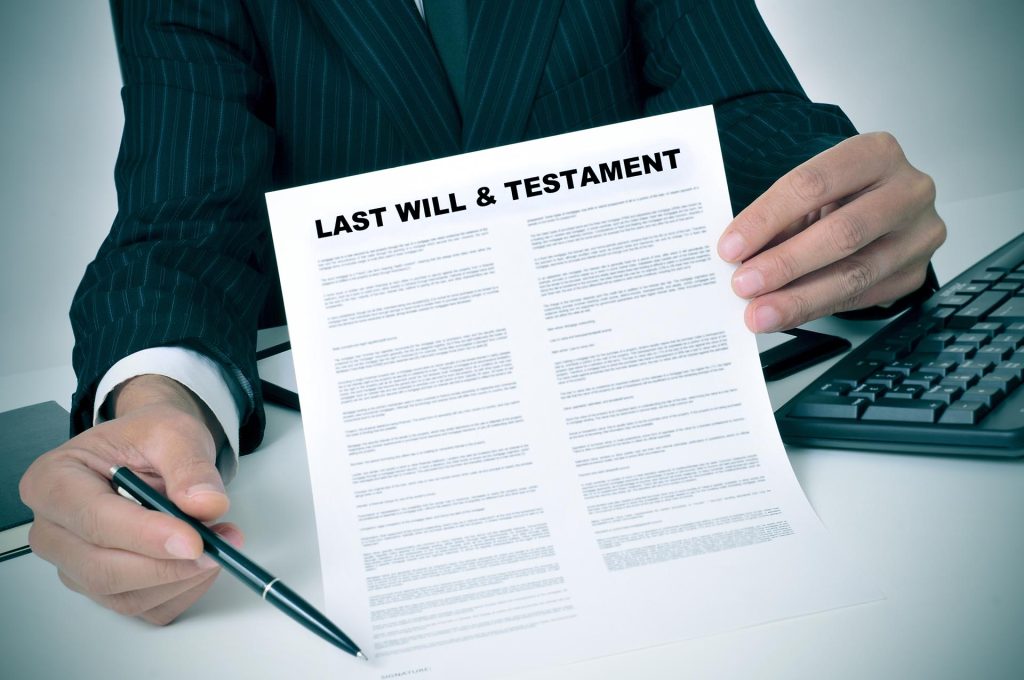 man in suit showing where the testator must sign in a last will and testament document